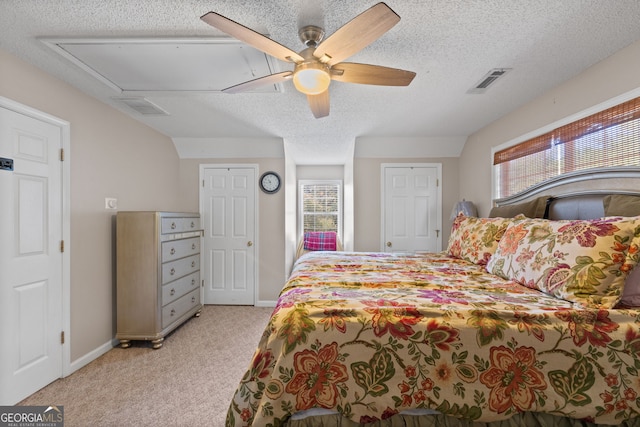 bedroom with light carpet, baseboards, visible vents, ceiling fan, and a textured ceiling