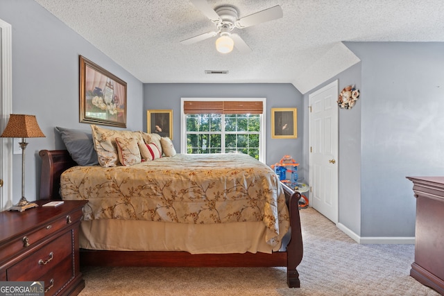 bedroom featuring light colored carpet, visible vents, ceiling fan, a textured ceiling, and baseboards