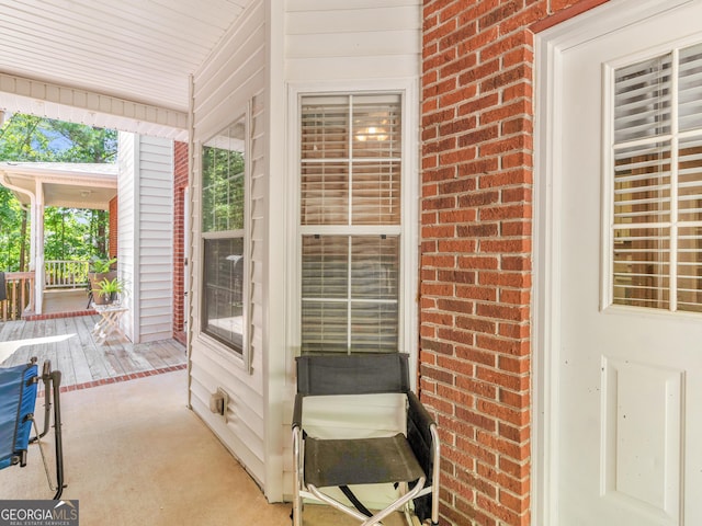 interior space with brick wall, plenty of natural light, and light colored carpet