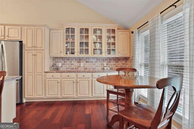 217 E Point Dr, Savannah, GA 31410 - kitchen featuring lofted ceiling, backsplash, glass insert cabinets, dark wood-style floors, and light stone counters
