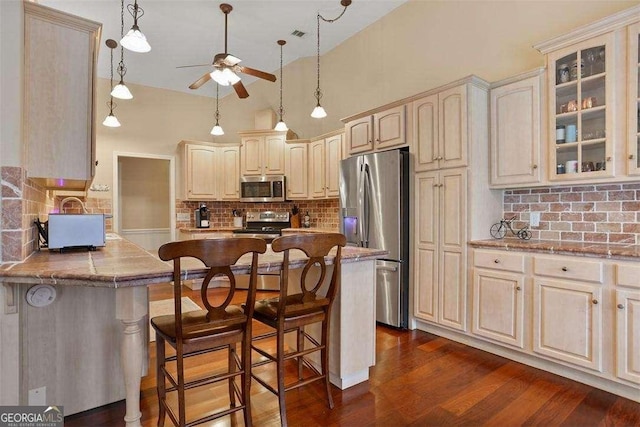 217 E Point Dr, Savannah, GA 31410 - kitchen with appliances with stainless steel finishes, ceiling fan, tasteful backsplash, a kitchen bar, and glass insert cabinets