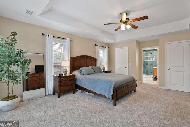 217 E Point Dr, Savannah, GA 31410 - bedroom featuring a tray ceiling, carpet floors, connected bathroom, and a ceiling fan