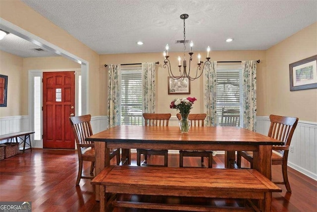 217 E Point Dr, Savannah, GA 31410 - dining area with a wainscoted wall, dark wood-style floors, a chandelier, a textured ceiling, and a decorative wall