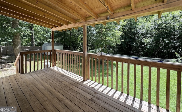 wooden deck featuring a lawn and a shed