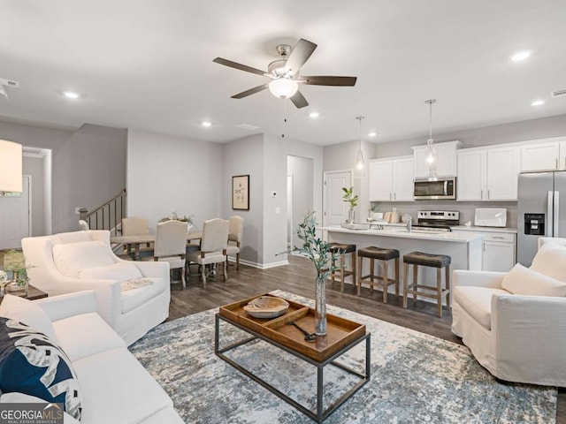 living room with ceiling fan and dark hardwood / wood-style floors