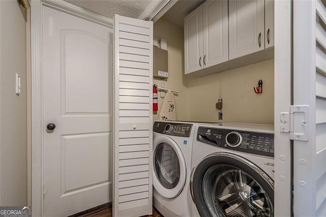 laundry area with cabinets and washing machine and clothes dryer