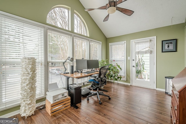 office space featuring dark hardwood / wood-style flooring, a textured ceiling, high vaulted ceiling, and ceiling fan