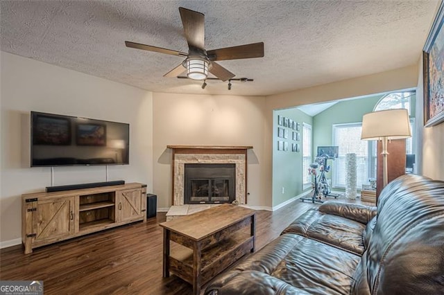 living room with lofted ceiling, dark wood-type flooring, a textured ceiling, and ceiling fan