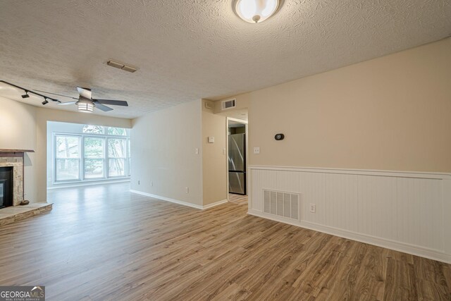 3205 Canyon Point Cir, Roswell, GA 30076 - living area with a glass covered fireplace, visible vents, a textured ceiling, and dark wood-type flooring
