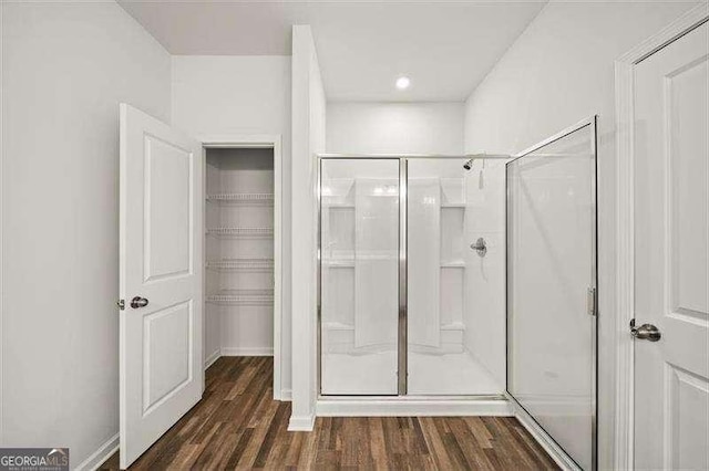 bathroom featuring wood-type flooring and an enclosed shower