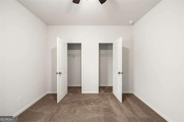 unfurnished bedroom with multiple closets, ceiling fan, and carpet floors