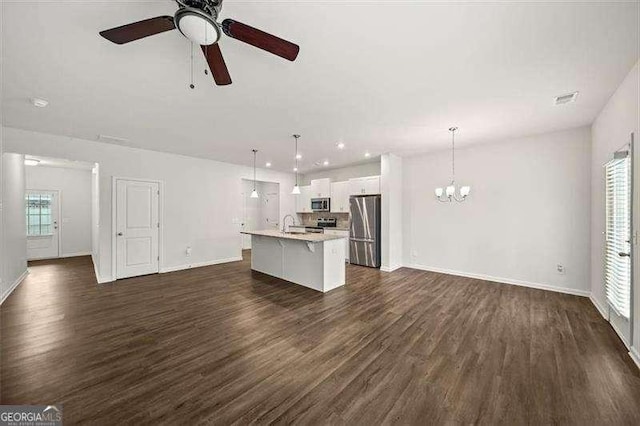 kitchen featuring stainless steel appliances, an island with sink, hanging light fixtures, and white cabinetry