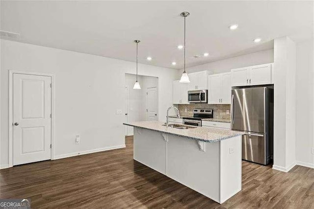 kitchen featuring decorative light fixtures, an island with sink, white cabinetry, sink, and stainless steel appliances