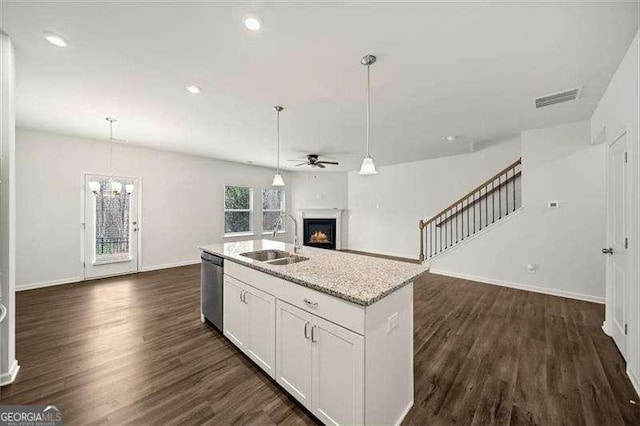 kitchen with sink, dishwasher, an island with sink, white cabinets, and ceiling fan with notable chandelier