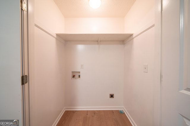 laundry room with hookup for a washing machine, electric dryer hookup, hardwood / wood-style flooring, and a textured ceiling