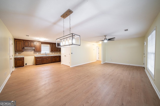 unfurnished living room featuring sink, ceiling fan, and light hardwood / wood-style flooring