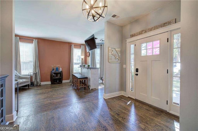 foyer entrance featuring dark hardwood / wood-style floors and a chandelier