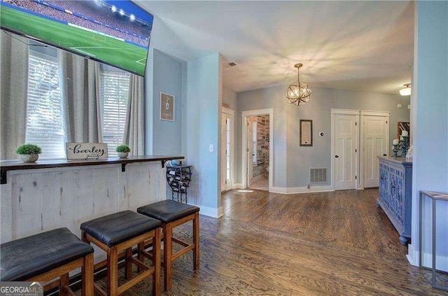 interior space featuring an inviting chandelier, blue cabinets, dark hardwood / wood-style flooring, and pendant lighting