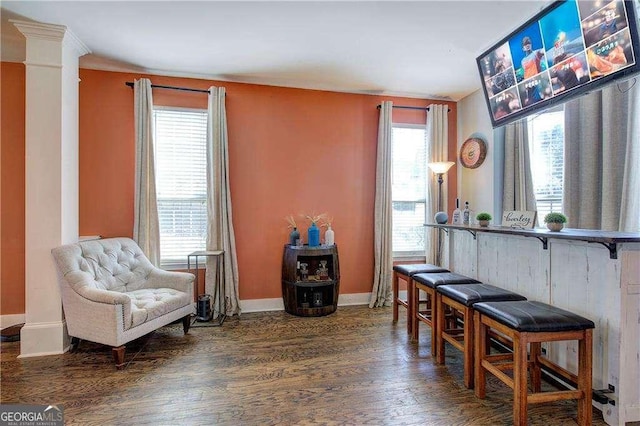 sitting room with dark hardwood / wood-style flooring and ornate columns