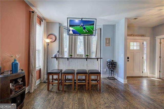 dining space with plenty of natural light and dark hardwood / wood-style flooring