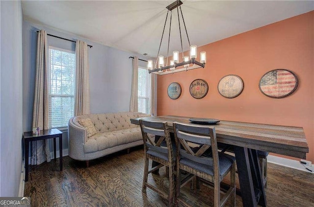 dining area with an inviting chandelier, dark wood-type flooring, and a healthy amount of sunlight