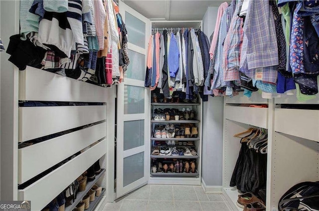 spacious closet with light tile patterned floors