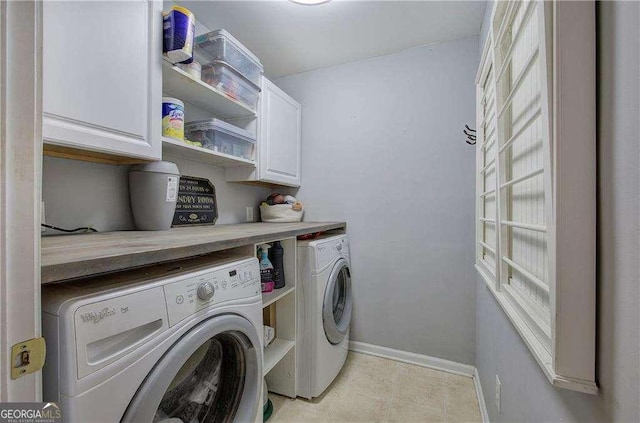 washroom with cabinets and washing machine and dryer