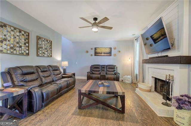 living room featuring hardwood / wood-style floors, a brick fireplace, and ceiling fan