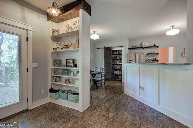 interior space with a barn door, dark hardwood / wood-style flooring, and stainless steel fridge with ice dispenser