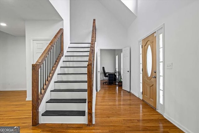 entryway featuring wood-type flooring and high vaulted ceiling