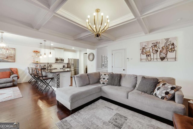 living room with coffered ceiling, dark hardwood / wood-style floors, a chandelier, and beam ceiling