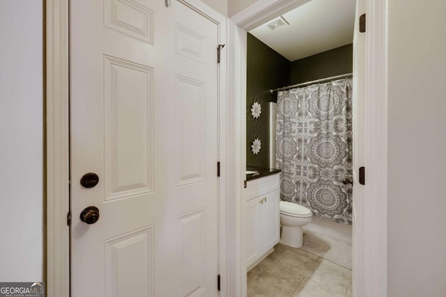 bathroom with tile patterned floors, vanity, toilet, and curtained shower