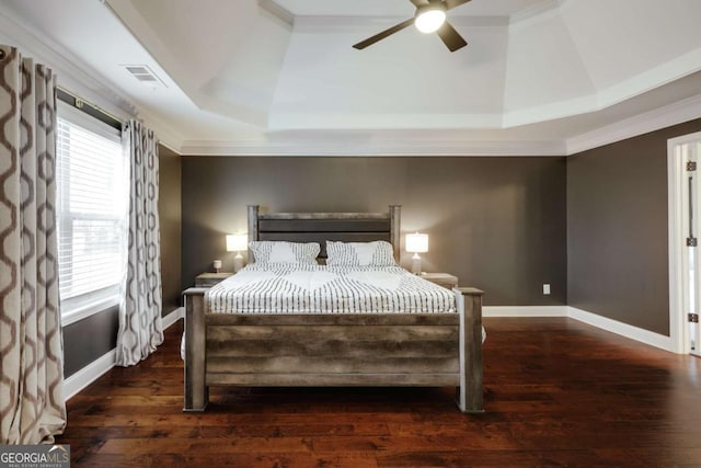 bedroom with dark hardwood / wood-style flooring, crown molding, a raised ceiling, and ceiling fan