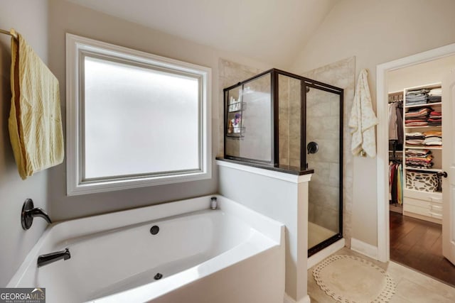 bathroom with shower with separate bathtub, tile patterned flooring, and vaulted ceiling