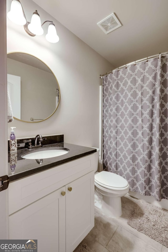 bathroom featuring tile patterned floors, toilet, and vanity