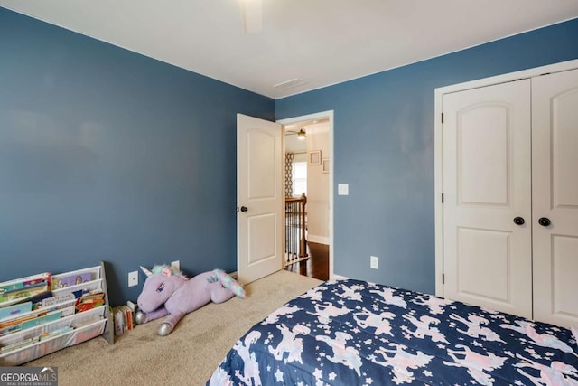 carpeted bedroom with ceiling fan and a closet