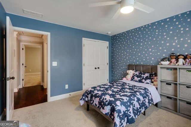 carpeted bedroom featuring ceiling fan and a closet