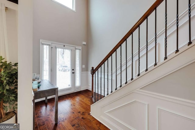 entrance foyer featuring a towering ceiling and dark wood-type flooring