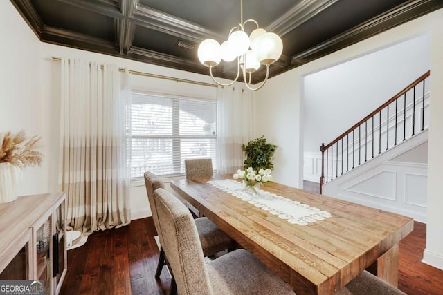 dining space featuring dark hardwood / wood-style flooring, coffered ceiling, crown molding, and an inviting chandelier