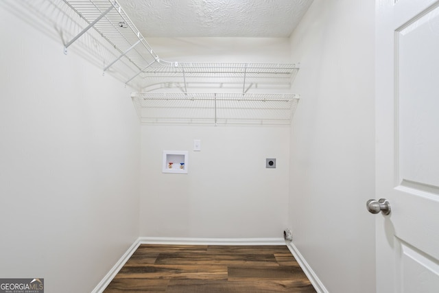 clothes washing area with electric dryer hookup, washer hookup, dark hardwood / wood-style floors, and a textured ceiling