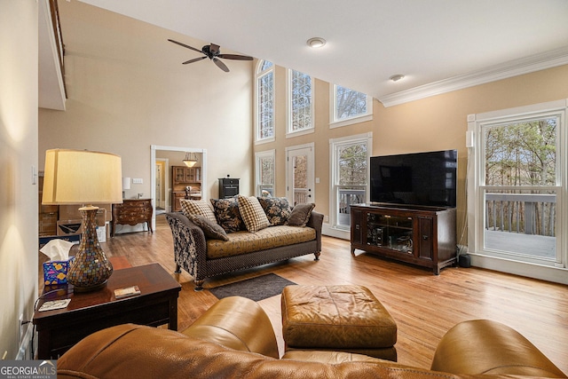 living room featuring light wood-style floors, ornamental molding, and ceiling fan