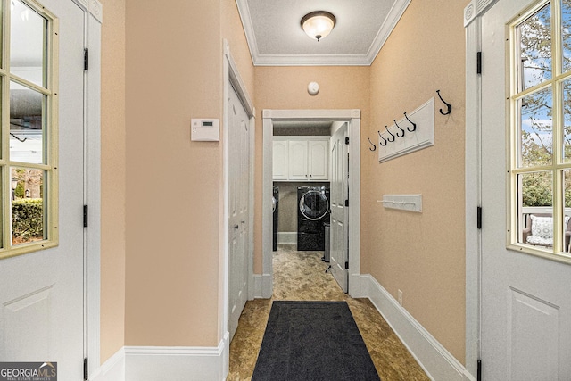 hallway with washing machine and dryer, crown molding, and baseboards