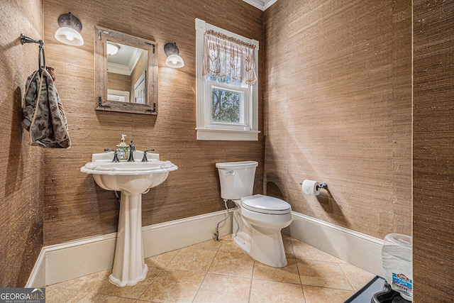 bathroom with toilet, tile patterned flooring, baseboards, and crown molding