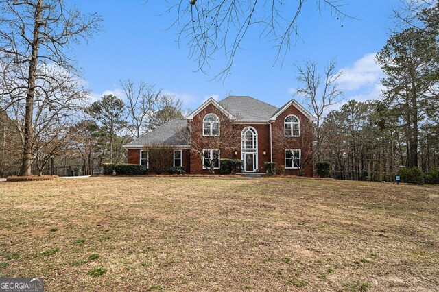 traditional-style house with a front yard and brick siding