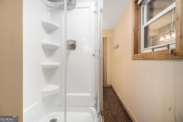 bathroom with a shower and baseboards