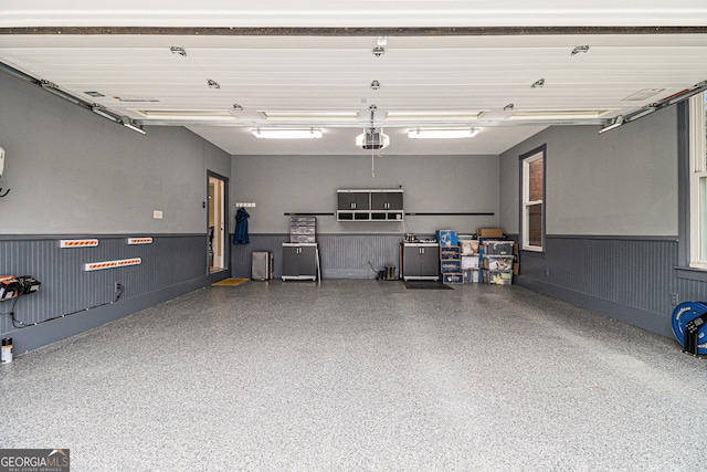 garage with a wainscoted wall and a garage door opener