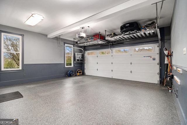 garage with a wainscoted wall and a garage door opener