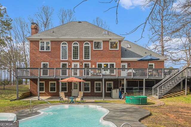 outdoor pool with an outbuilding, a lawn, a hot tub, and a diving board