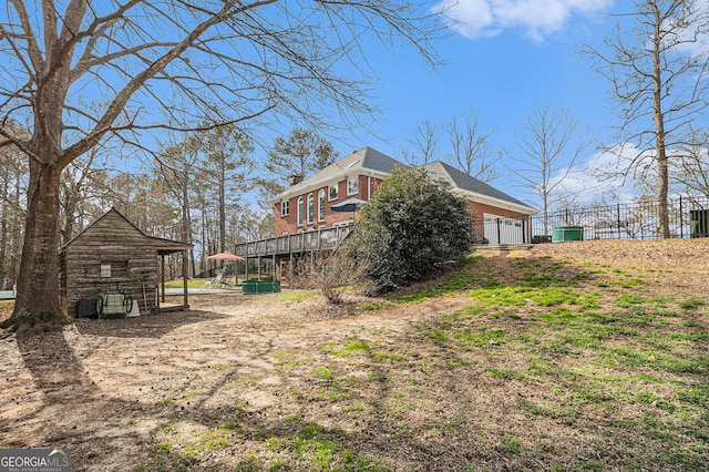 view of side of property featuring a chimney, fence, and brick siding