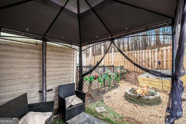 view of yard featuring an outdoor fire pit, fence, and a gazebo